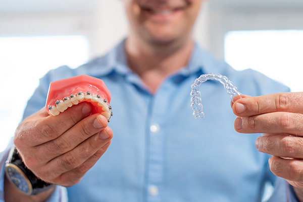 Dental Care.smiling Dentist Doctor Holding Aligners And Braces I